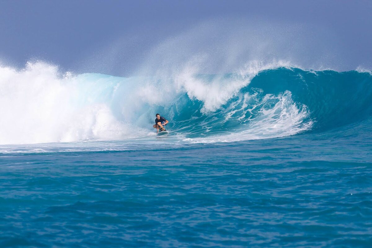 Kian surfing a large wave
